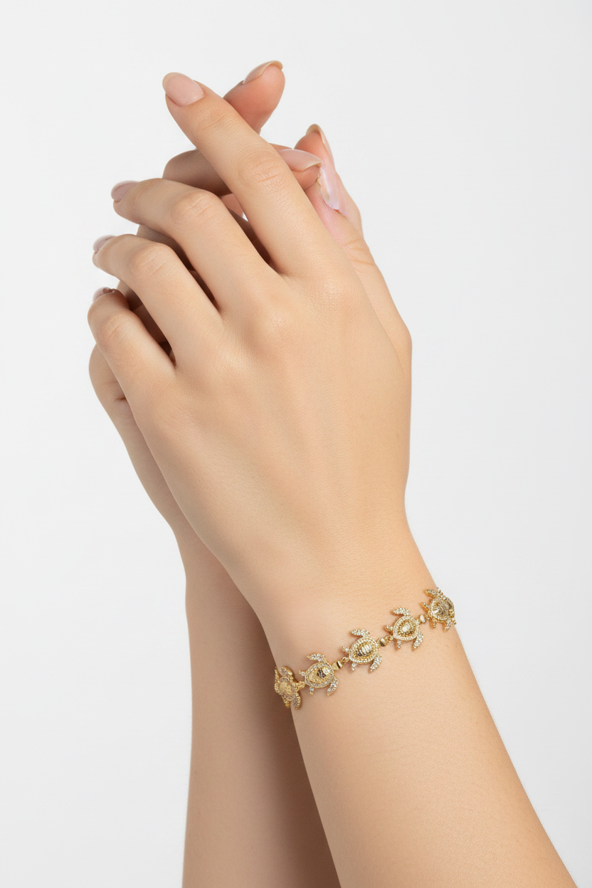 Gold bracelet on a person's wrist with a plain background
