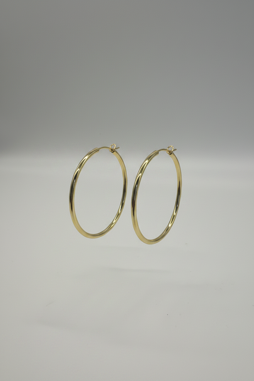 Gold hoop earrings on a gray background