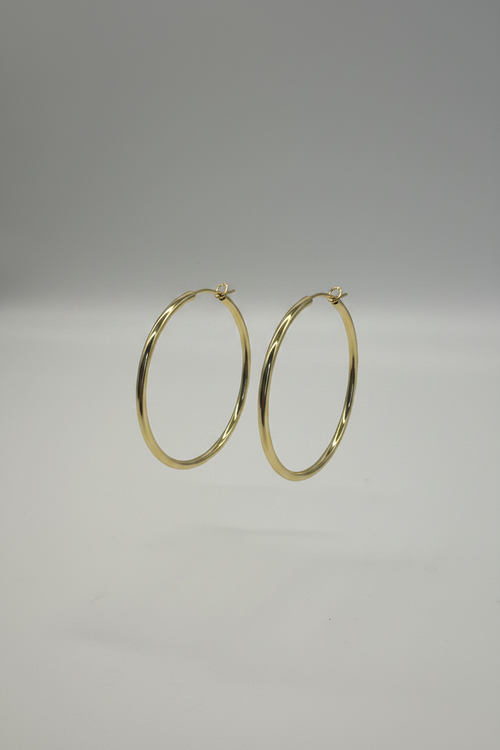 Gold hoop earrings on a gray background