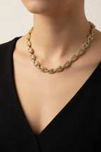 Gold necklace on a mannequin with a plain background