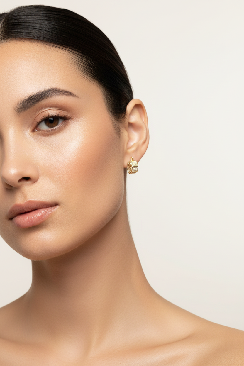 Close-up of a woman wearing gold earrings on a light background