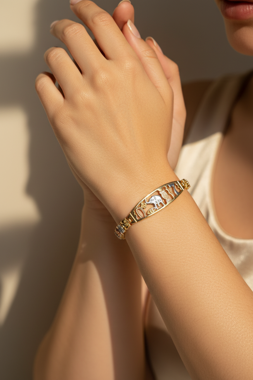Close-up of a hand wearing a gold bracelet with intricate designs.